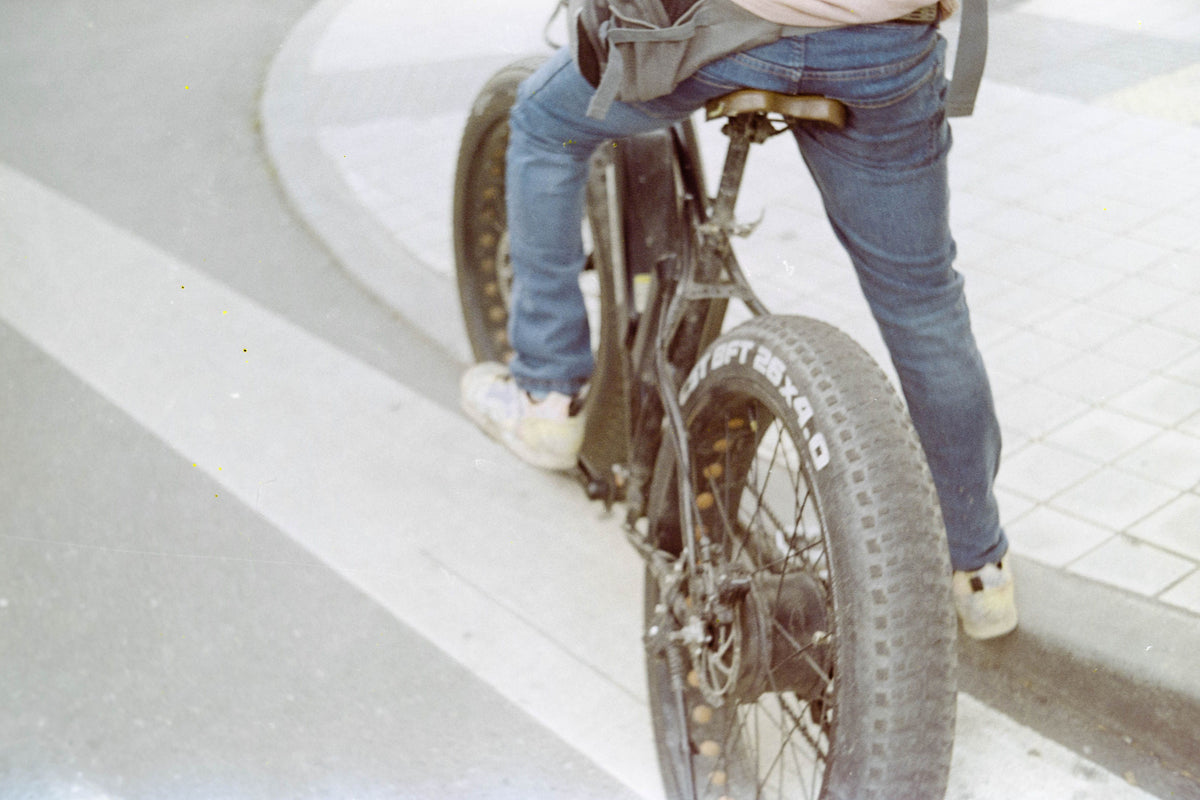 Cycliste roulant sur un vélo électrique à pneus larges dans une rue urbaine