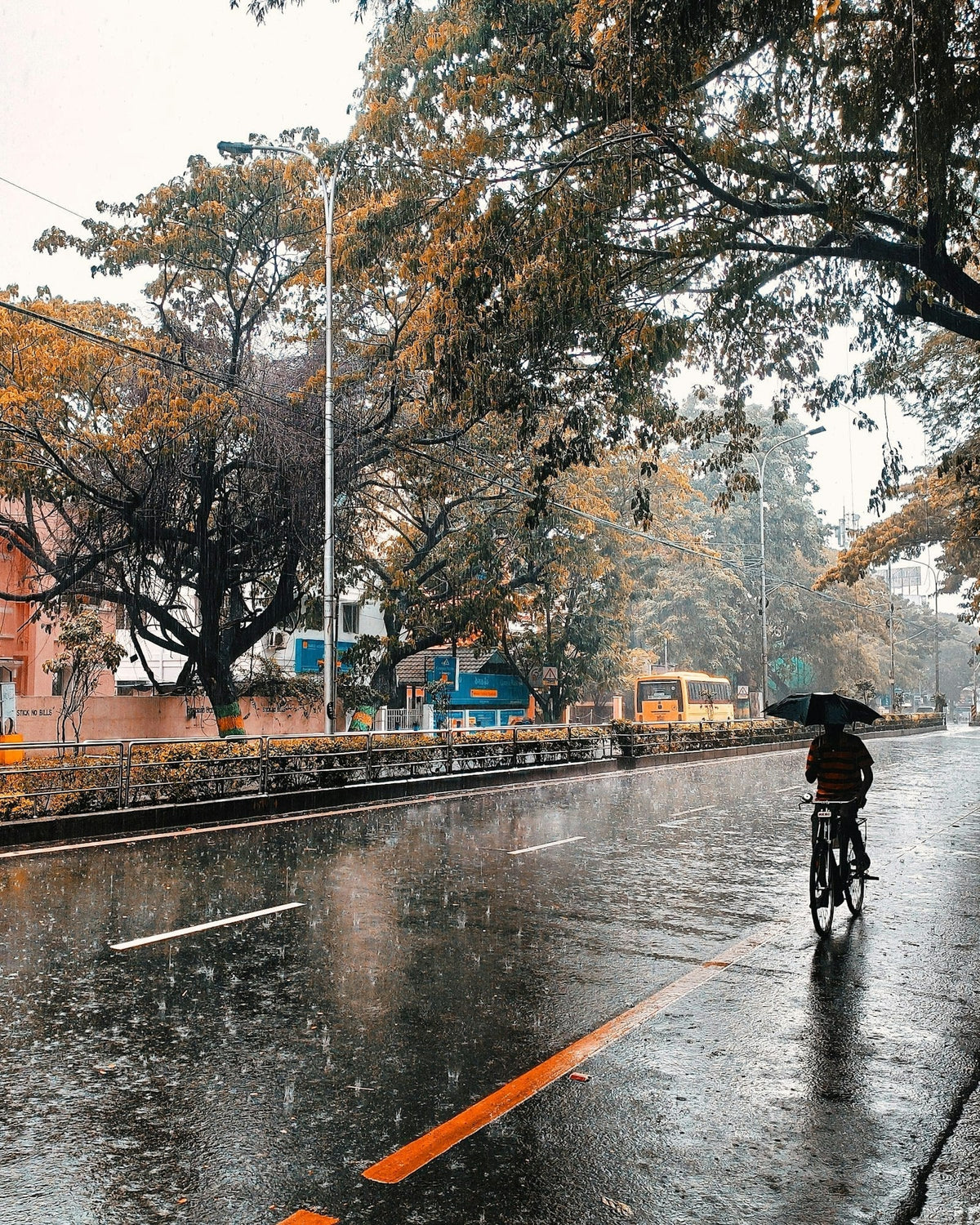 Cycliste roulant sous la pluie sur une route mouillée en ville